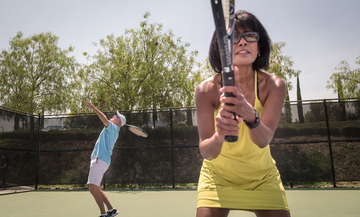Couple playing tennis at Trilogy Vineyards